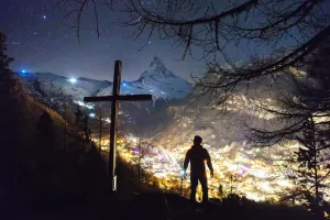 Person standing in front of an illuminated church, illustrating Christian counseling