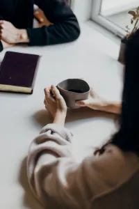 Person holding a mug during a conversation