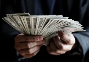 Hands holding cash, illustrating financial motivation