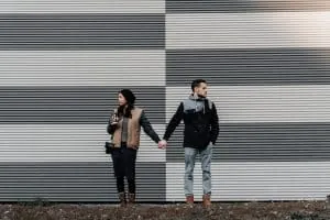 Couple holding hands while looking in different directions