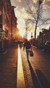 Person walking away along a sunlit street