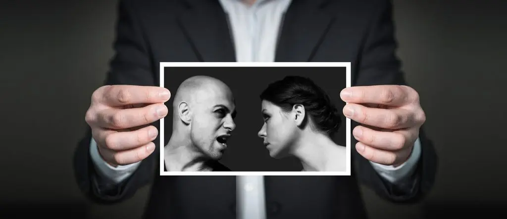 Person holding a photograph of a couple arguing, illustrating relationship secrets