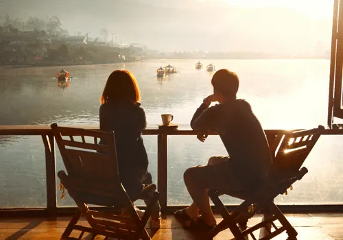 Couple sitting beside a lake on a getaway