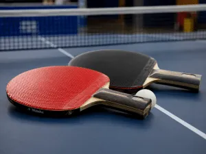 Table-tennis paddles and a ball illustrating back-and-forth trauma responses