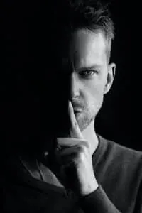Person gesturing to keep a secret