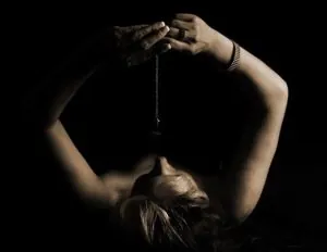 Woman stretching with her hands above her head, illustrating self-hypnosis and relaxation