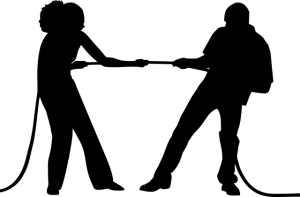 Silhouettes of two people pulling in opposite directions during relationship conflict