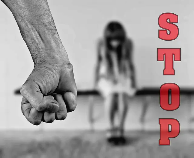 Stop message beside an adult's clenched fist and a child, illustrating abuse prevention
