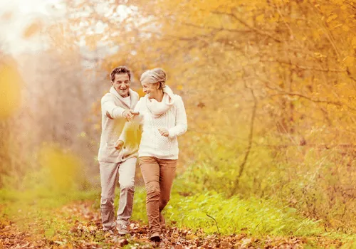 Couple walking together through autumn foliage